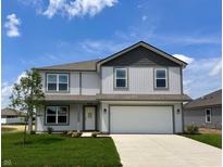 Charming two-story home featuring a two-car garage, landscaped yard, and a welcoming front entrance at 1204 Mcbride St, Greenfield, IN 46140