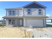 Charming two-story home featuring a two-car garage, light gray siding, and a covered front porch at 1204 Mcbride St, Greenfield, IN 46140