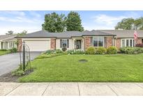 Charming ranch-style home with a well-manicured lawn and inviting curb appeal in a peaceful neighborhood at 12388 Camberley Ln, Carmel, IN 46033
