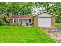 Charming brick home with a well-maintained lawn, brick chimney, and attached one car garage at 2228 Dover St, Anderson, IN 46013