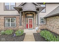 Charming front entrance with a red door, brick facade, and well-maintained landscaping creating curb appeal at 2802 Singletree Dr, Indianapolis, IN 46234