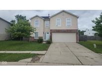 Two-story home featuring light siding, red brick accents, a two-car garage, and a well-maintained front lawn at 3059 Black Forest Ln, Indianapolis, IN 46239