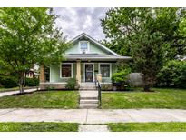 Charming bungalow featuring a well-maintained lawn and inviting front porch at 309 N Riley Ave, Indianapolis, IN 46201