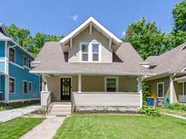 Charming craftsman home featuring a welcoming front porch and a well-manicured lawn at 344 N Whittier Pl, Indianapolis, IN 46219
