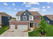 Beautiful two-story home with a brick and blue facade, well-manicured lawn, and a three-car garage at 3948 Saddle Club S Pkwy, Bargersville, IN 46106