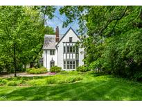 Charming white two-story home surrounded by lush green lawn and mature trees at 4410 N Pennsylvania St, Indianapolis, IN 46205