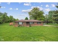 Charming brick home with a well-maintained lawn, mature trees, and blooming flowerbeds at 522 E County Road 1000 S, Clayton, IN 46118