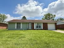 Charming one-story home featuring a lush green lawn, attached garage, and a welcoming entrance at 539 Willow Dr, Danville, IN 46122