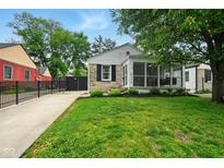 Charming home featuring a screened porch, stone accents, and a well-maintained lawn and driveway at 6176 Kingsley Dr, Indianapolis, IN 46220