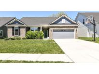 Charming brick home featuring a two-car garage, well-manicured lawn, and inviting curb appeal at 6832 Oakcrest Dr, McCordsville, IN 46055