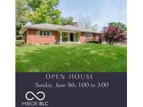 Charming one-story red brick home with a well-manicured lawn and covered front porch at 7135 Huntington Rd, Indianapolis, IN 46240