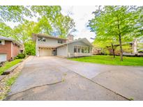 Charming two-story home features a long driveway, inviting curb appeal, and lush green landscaping at 806 Maplewood Ave, Anderson, IN 46012