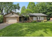 Charming single-story home with a brick facade, well-maintained lawn, and attached two-car garage at 8218 San Carlos Ct, Indianapolis, IN 46256