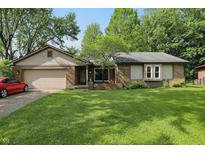 Charming single-story brick home with a well-manicured lawn and attached two-car garage at 8218 San Carlos Ct, Indianapolis, IN 46256