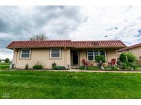 Charming single-story home with a red tile roof and a well-manicured green lawn at 8362 Punto Alto Dr, Indianapolis, IN 46227