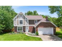 Charming two-story Tudor-style home with a brick and siding exterior, well-manicured lawn, and an attached two-car garage at 9832 Scotch Pine Ln, Indianapolis, IN 46256