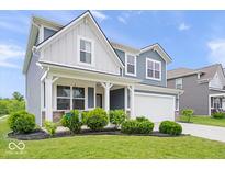 Charming two-story home with blue siding, white trim, covered porch, landscaped yard, and attached two-car garage at 10419 Pronghorn Ln, Indianapolis, IN 46239