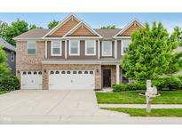 Charming two-story brick and siding home with a well-manicured lawn and attached two-car garage at 1274 Timber Bluff Rd, Westfield, IN 46074