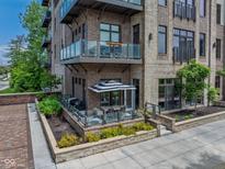 Stunning condominium with brick facade, glass balconies, and a private patio area at 15 W Executive Dr # 101, Carmel, IN 46032