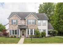 Charming two-story home with a brick facade, manicured lawn, and beautiful landscaping at 1680 Arbor Springs Dr, Brownsburg, IN 46112