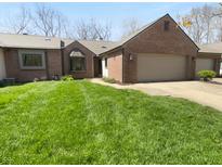 Charming brick home featuring an attached two-car garage and well-maintained front lawn at 1726 Creekside W Ln, Carmel, IN 46032