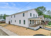 Charming two-story home with white siding, inviting front porch and tastefully mulched lawn at 1825 E Maryland St, Indianapolis, IN 46201