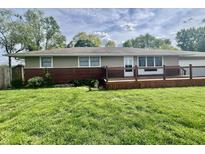 Ranch-style home featuring brick accents, a wooden deck, and a well-maintained green lawn at 1927 E 125 S, Franklin, IN 46131