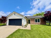 Charming single-story home with a well-maintained lawn and a two-car garage on a beautiful day at 204 Meadow Creek S Dr, Whiteland, IN 46184