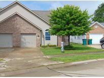 Charming home featuring a two-car garage, brick accents, and a well-manicured lawn with mature tree at 2116 Galaxy Dr, Franklin, IN 46131