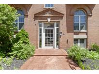 Charming brick building entrance featuring glass door, arched windows, and well-maintained landscaping at 404 E New York E St # 406, Indianapolis, IN 46202