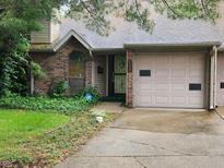 Traditional brick townhome featuring a garage, complemented by a well-maintained yard at 4336 Abby Creek Ln, Indianapolis, IN 46205
