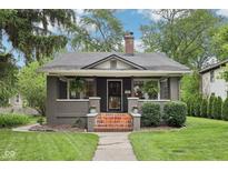 Charming bungalow with brick accents, a cozy front porch, and well-manicured landscaping at 5117 N Park Ave, Indianapolis, IN 46205