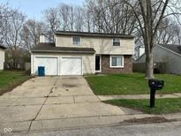 Charming two-story home featuring a well-maintained lawn and an attached two-car garage at 5735 Liberty Creek E Dr, Indianapolis, IN 46254