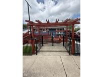 Charming backyard featuring a pergola, deck, and black metal fencing at 6126 Regina Cir, Indianapolis, IN 46224