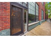 Stylish entrance with large windows and a modern brick facade exudes urban charm and elegance at 630 N College Ave # 105, Indianapolis, IN 46204