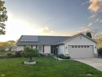 Charming single-story home with solar panels, manicured lawn, and attached two-car garage at 6406 Longhorn Ct, Indianapolis, IN 46237