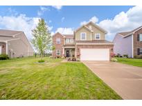 Charming two-story home with brick and siding exterior, a well-manicured lawn, and a driveway at 6579 Aster Dr, Pendleton, IN 46064
