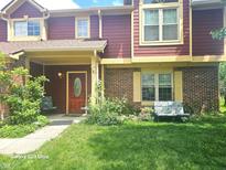 Inviting two-story townhouse featuring a brick and red siding exterior, complemented by a well-maintained front lawn at 6723 Silver Tree Dr, Indianapolis, IN 46236