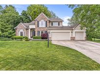 Charming two-story home with brick and siding exterior, manicured lawn, and attached three-car garage at 6833 Bluffridge Ln, Indianapolis, IN 46278