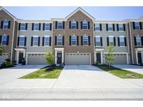 Charming townhome featuring a well-maintained lawn, attached garage and inviting curb appeal at 6871 Adalene Ln, Carmel, IN 46033