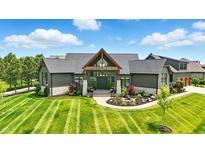 Stunning home with a modern design, beautiful landscaping, and inviting entrance at 7116 Trail Ridge Ln, Indianapolis, IN 46259