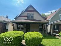 Modest two-story home featuring a covered front porch and neutral siding at 811 W 25Th St, Indianapolis, IN 46208