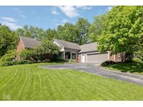 Charming brick home featuring an attached two-car garage and a well-manicured front lawn at 8330 Claridge Rd, Indianapolis, IN 46260
