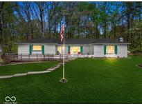 Charming single-story home featuring a well-maintained lawn, wood deck, and inviting curb appeal at 8581 N Goat Hollow Rd, Mooresville, IN 46158