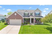 Charming two-story home with a brick facade, covered porch, and well-manicured lawn at 8635 Nolan Dr, Fishers, IN 46038