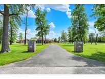Long driveway leading to a brick home with a lush green lawn and mature trees at 893 W 500 S, Anderson, IN 46013