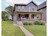 Charming two-story home with a welcoming front porch, brick accents, and well-manicured lawn at 1009 Broadway St, Indianapolis, IN 46202
