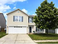 Charming two-story home with a well-manicured lawn, beautiful tree, and attached two-car garage at 10836 Zimmerman Ln, Indianapolis, IN 46231