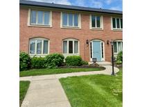 Charming brick townhouse with a blue front door and well-maintained landscaping at 1150 Canterbury Ct # Apt D, Indianapolis, IN 46260