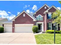 Beautiful red brick home featuring a three car garage, well manicured lawn, and a perfectly landscaped yard at 12044 Bird Key Blvd, Fishers, IN 46037